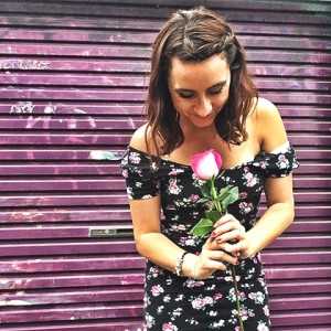 Katie Morris, Social Media Community Manager, holding a rose